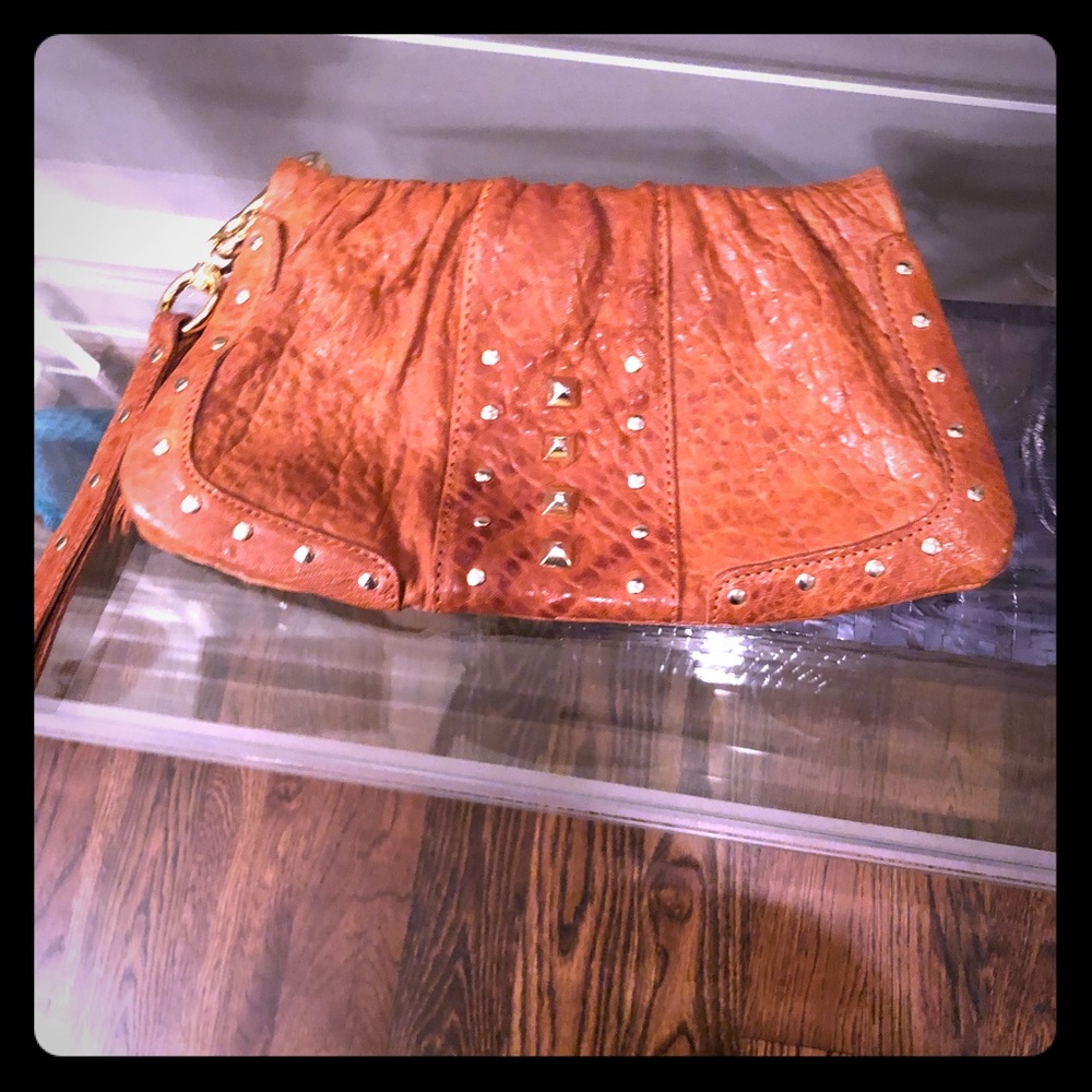 Tan wristlet clutch with gold details.